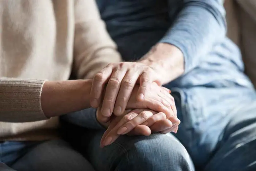 elderly couple holding hands
